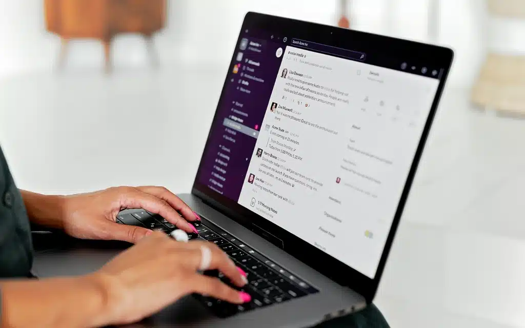 Woman typing on a laptop in a modern office setting illustrating Answer Engine Optimization (AEO) and digital search marketing concept
